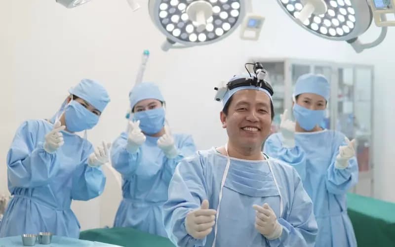 Êkip bác sĩ phòng mổ tươi cười chuyên nghiệp